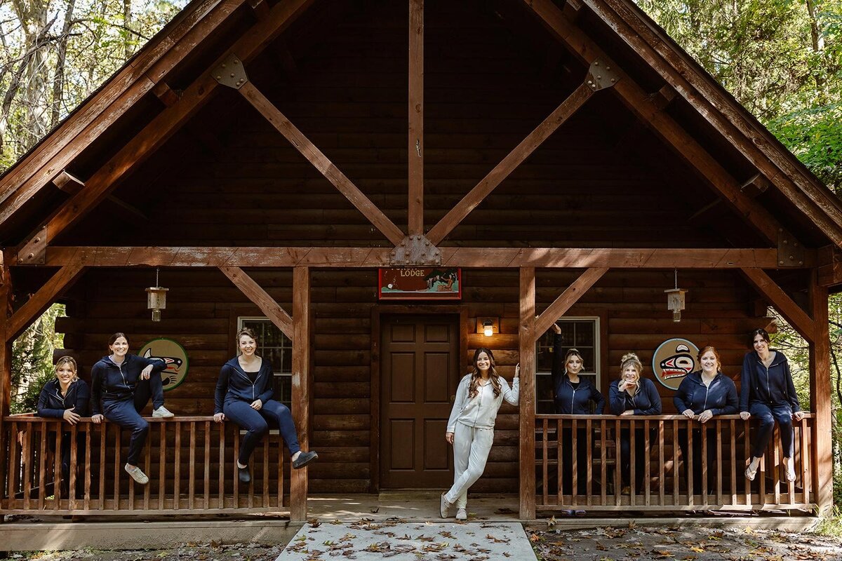 A bridee and her bridesmaids stand in matching sweatsuits in front of the cain where they were getting ready for the wedding