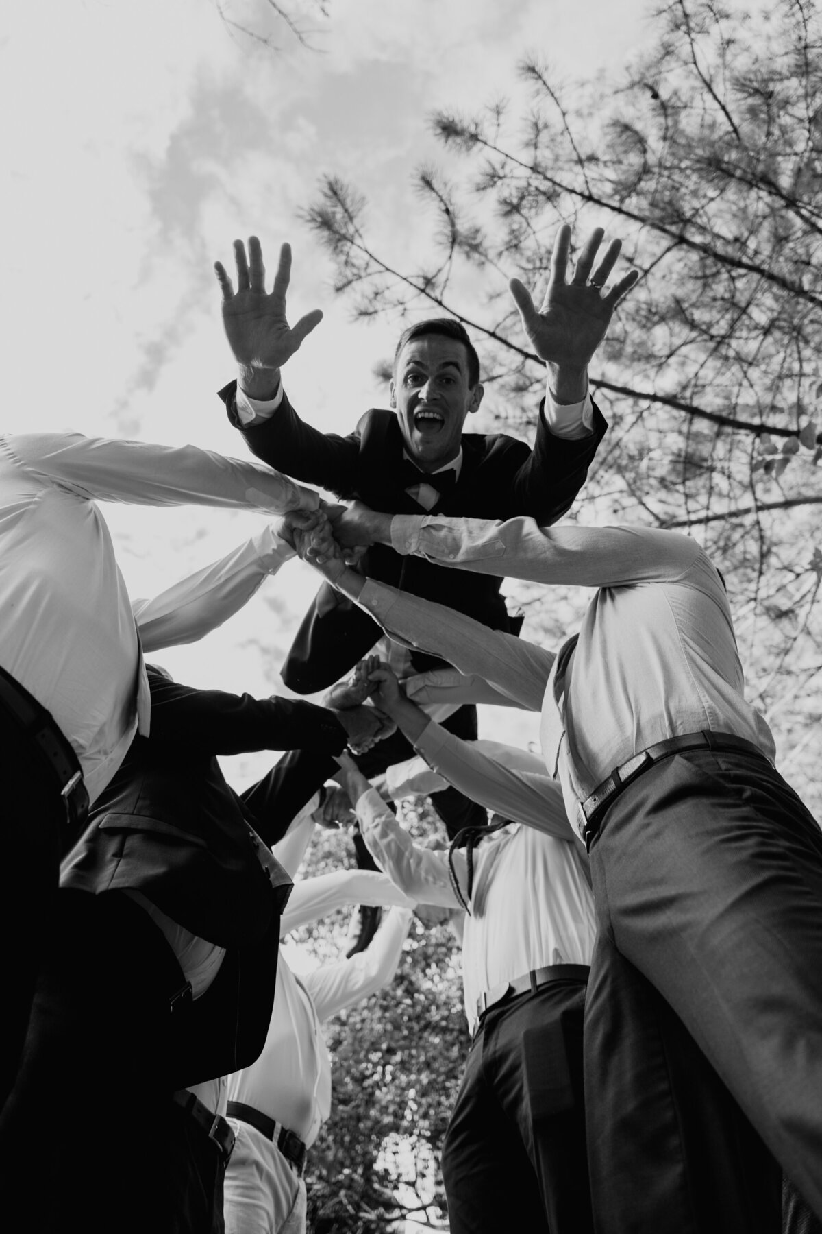Groom jumping with veil thrown in the air