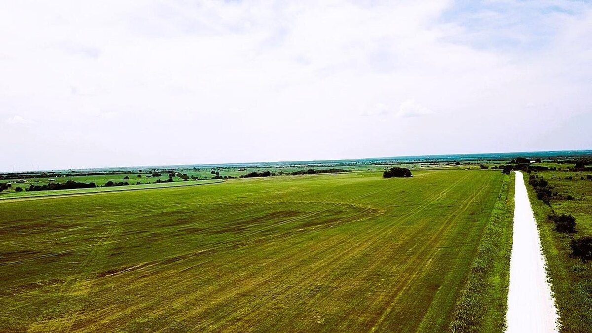 Aerial view of 11-acre property in Lindsay, Texas with open fields and clear skies