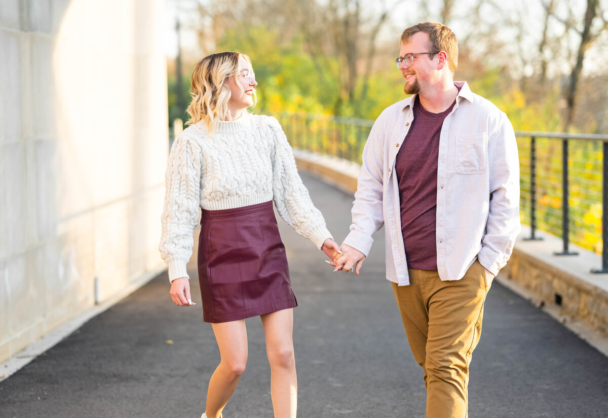 woman and man holding hands walking and laughing