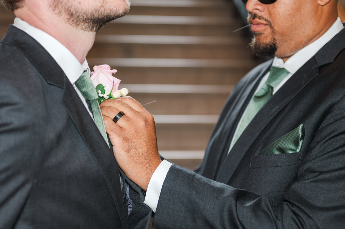 groomsmen putting on groom's boutonniere