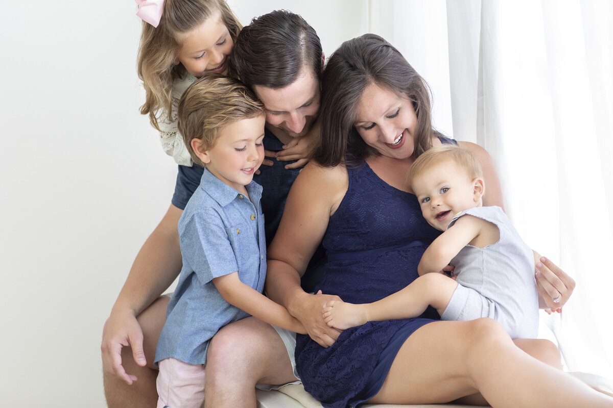 Maternity photo of a pregnant mom with her three children and partner, all smiling together—captured by Philadelphia maternity photographers.