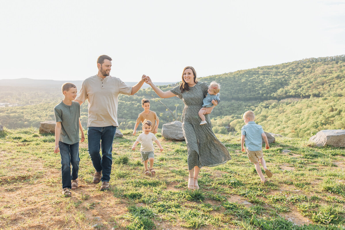 playful family on top of mountain overlook