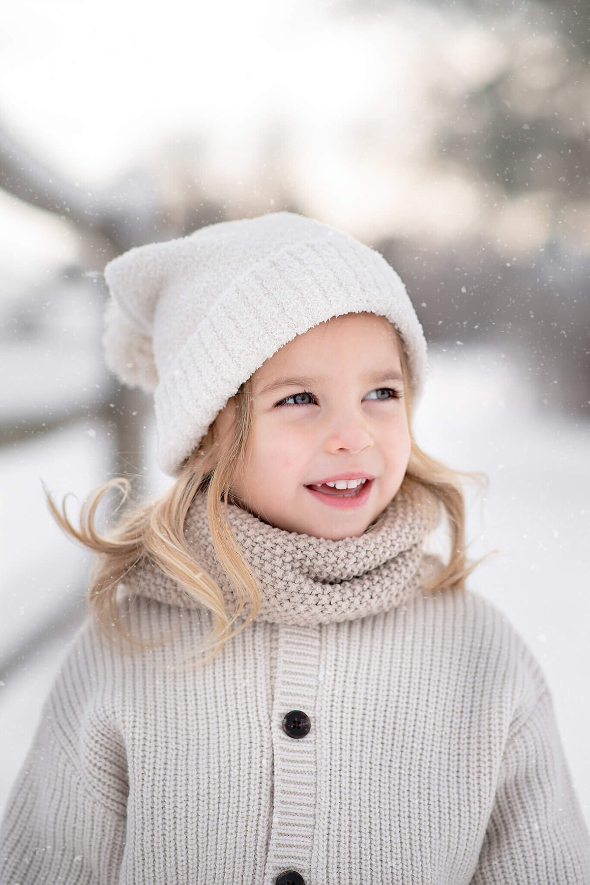 Brittany Danielle captures a beautiful winter portrait of a little girl wiht blonde hair wearing a white toque in Kamloops.