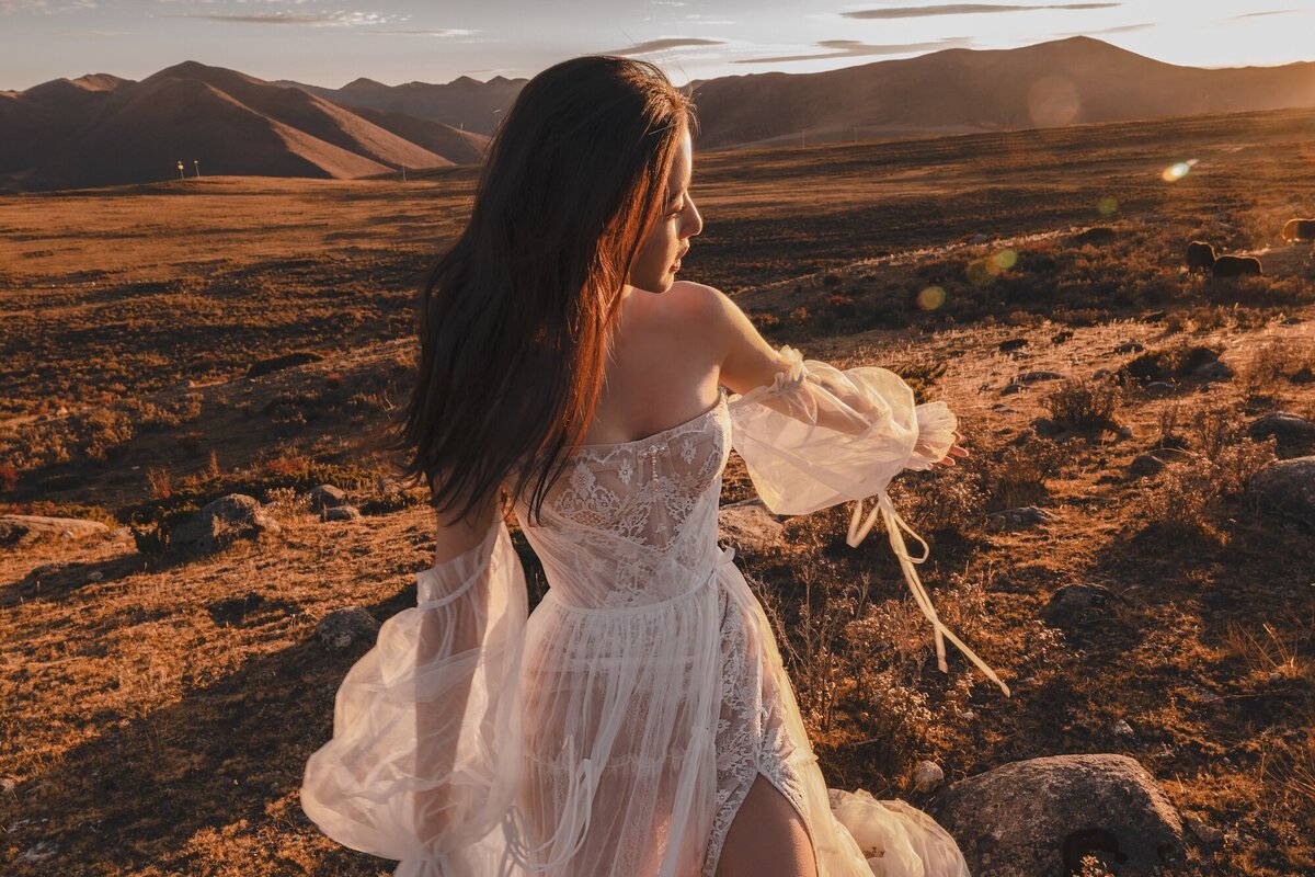 A beautiful woman in a couture dress photographed in fields during golden hour.