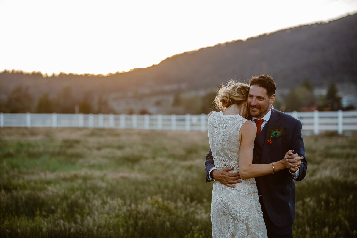 Ali and Brian hold one another in a field.