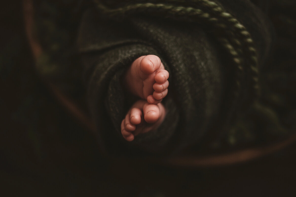 Newborn toes in green blanket