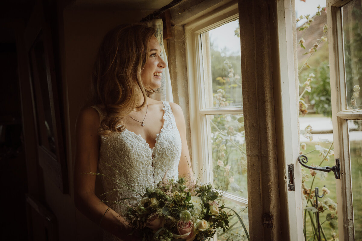 A bride looking out of a window in natural light