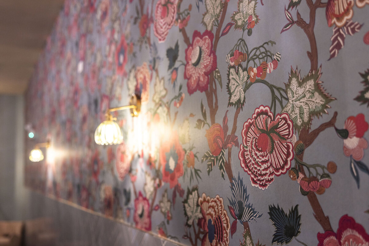 detail shot of hand picked and designed wallpaper and sconce detail of women's bathroom in Bloom Events space