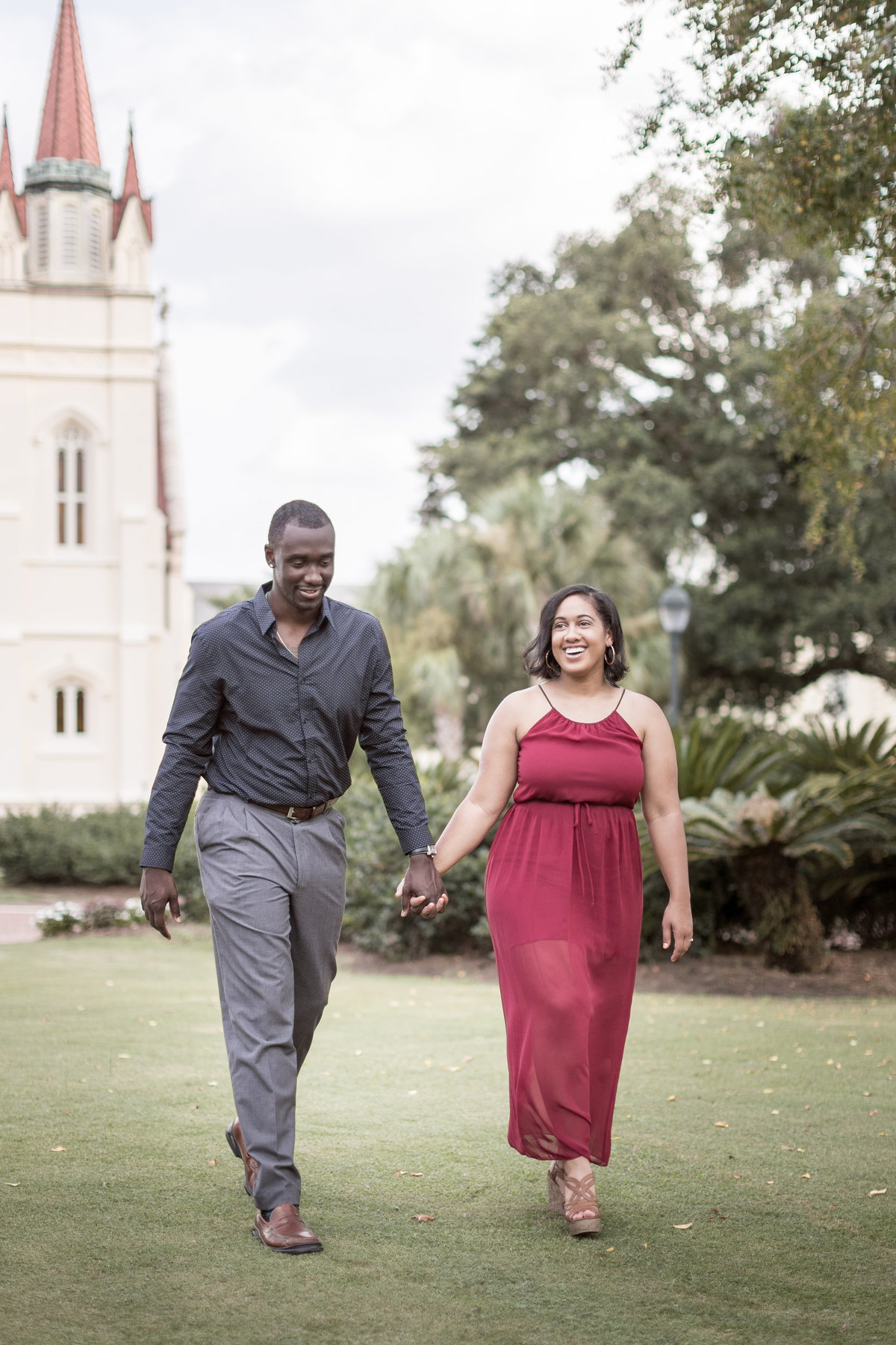 The newly engaged couple takes a stroll on the lawn of St. Joseph's Chapel at Springhill College in Mobile, Alabama.