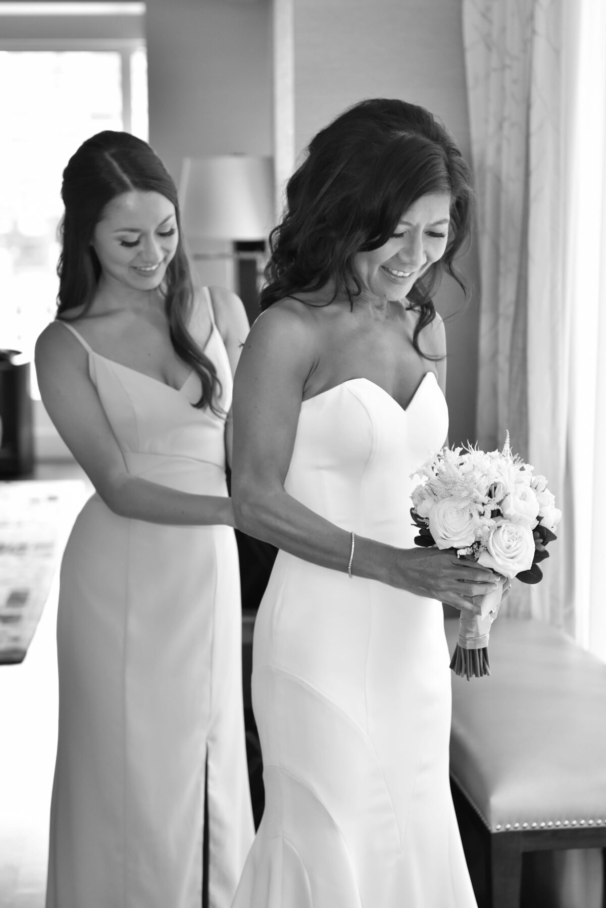 bride-helped-by-bridesmaid-wedding-dress