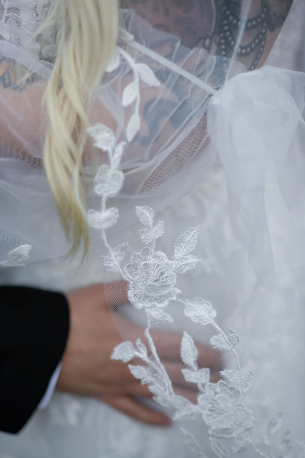 bridal detail photo of groom holding his brides waist as her veil falls over her waist captured by gatlinburg photographers for Ely's Mill elopement 