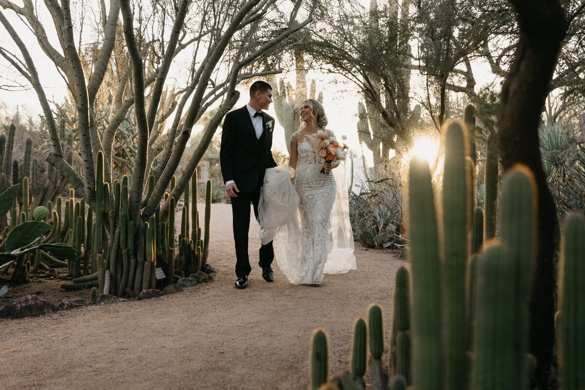 bride and groom walking through desert