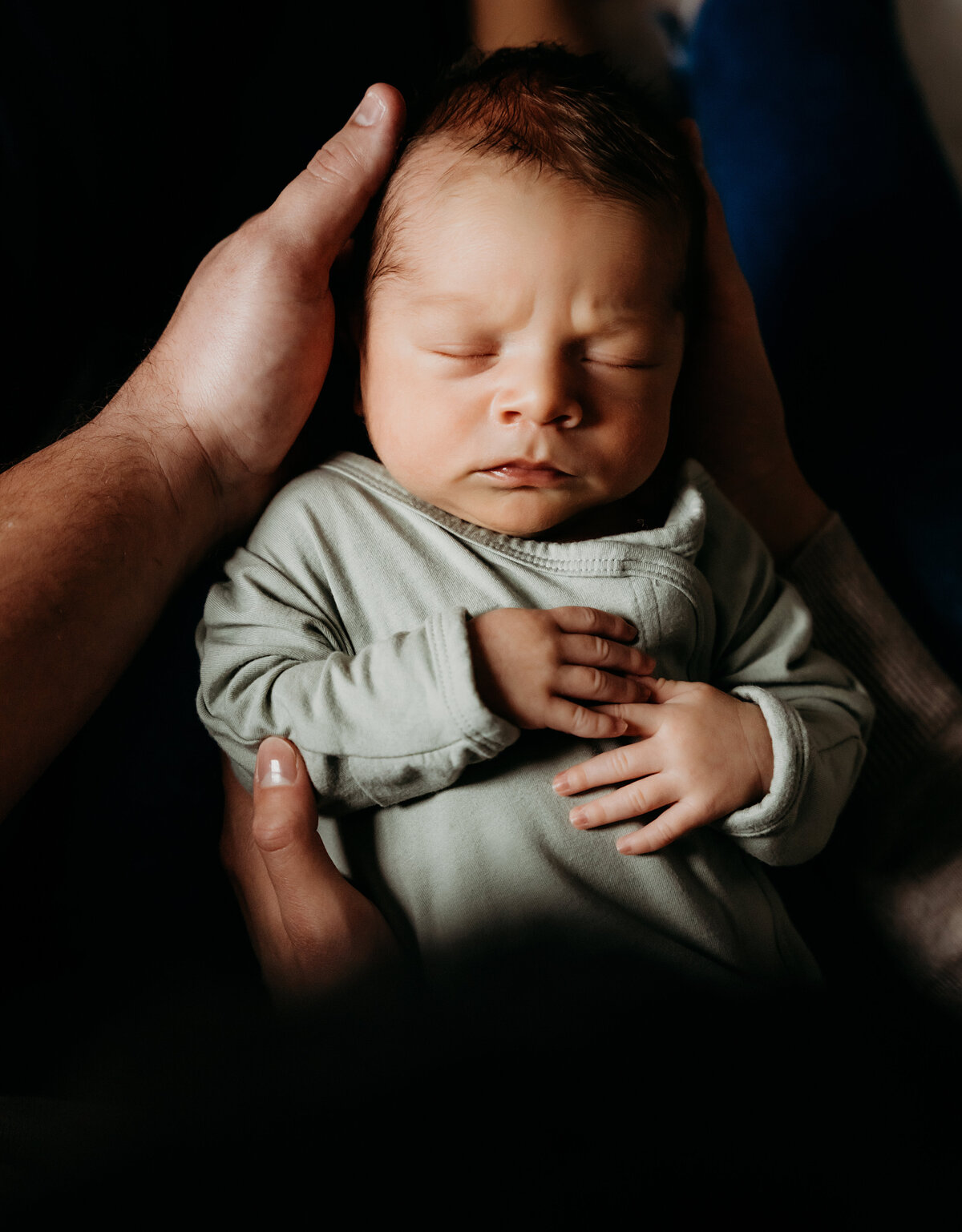 Newborn Photographer,  a baby boy sleeps in his mother's arms