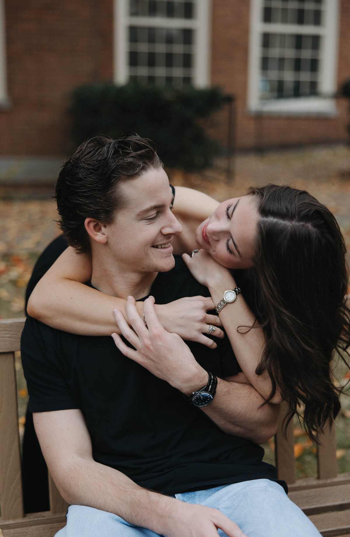 engaged couple with the woman leaning over the mans shoulder, resting her head on his shoulder