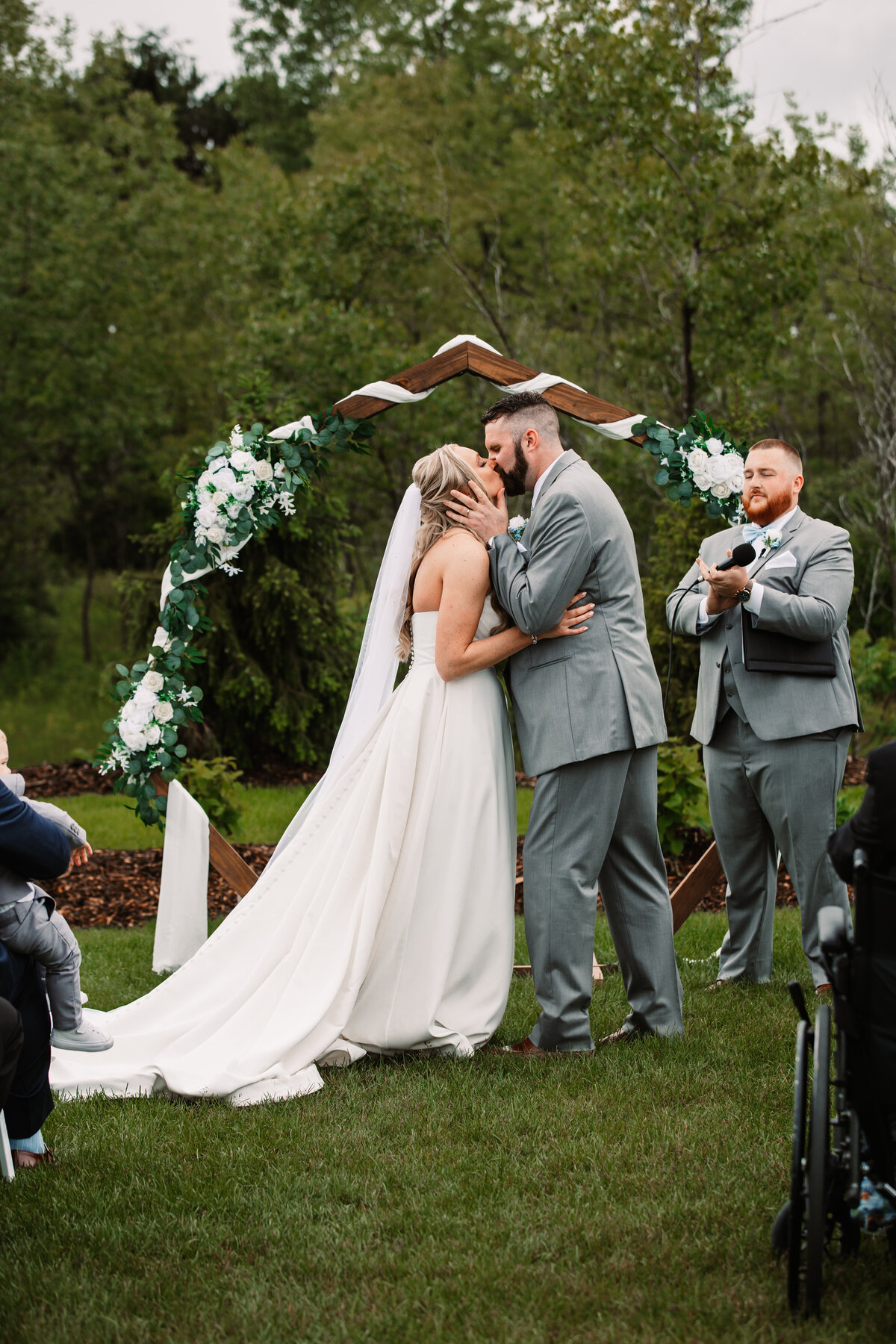 Newlyweds kiss under the arbor to end their ceremony