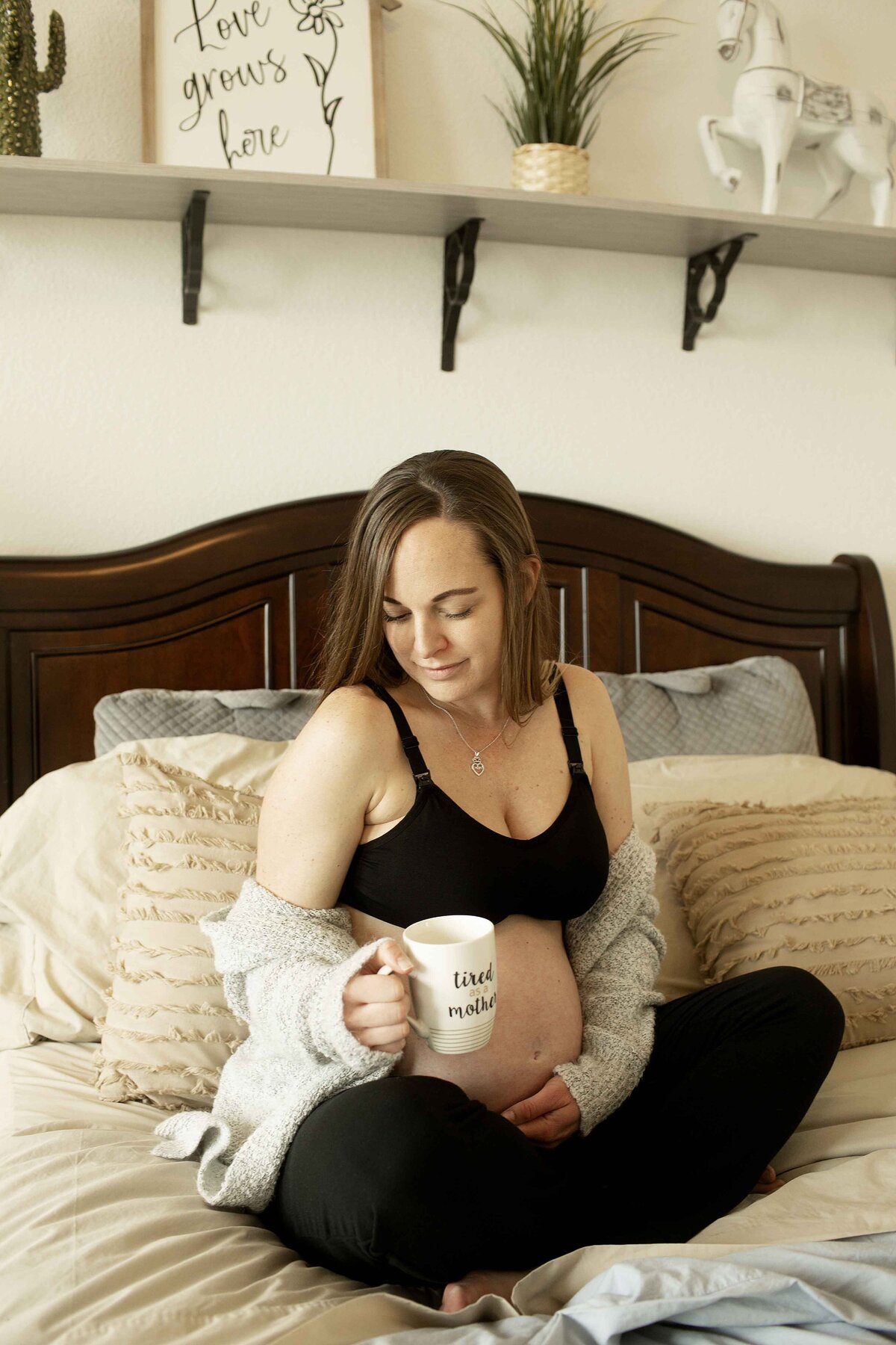A tender maternity moment of mom alone on the bed, lovingly looking at her belly with hands resting on her baby bump, the soft, natural light creating a calm atmosphere, captured by Chunky Monkey Photography.