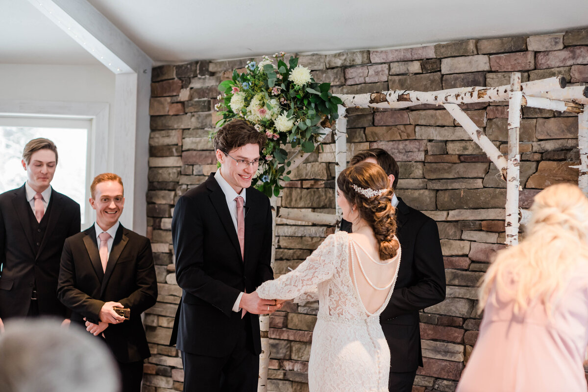 Bride and groom hold hands at the alter at their ceremony captured by denver wedding photographer