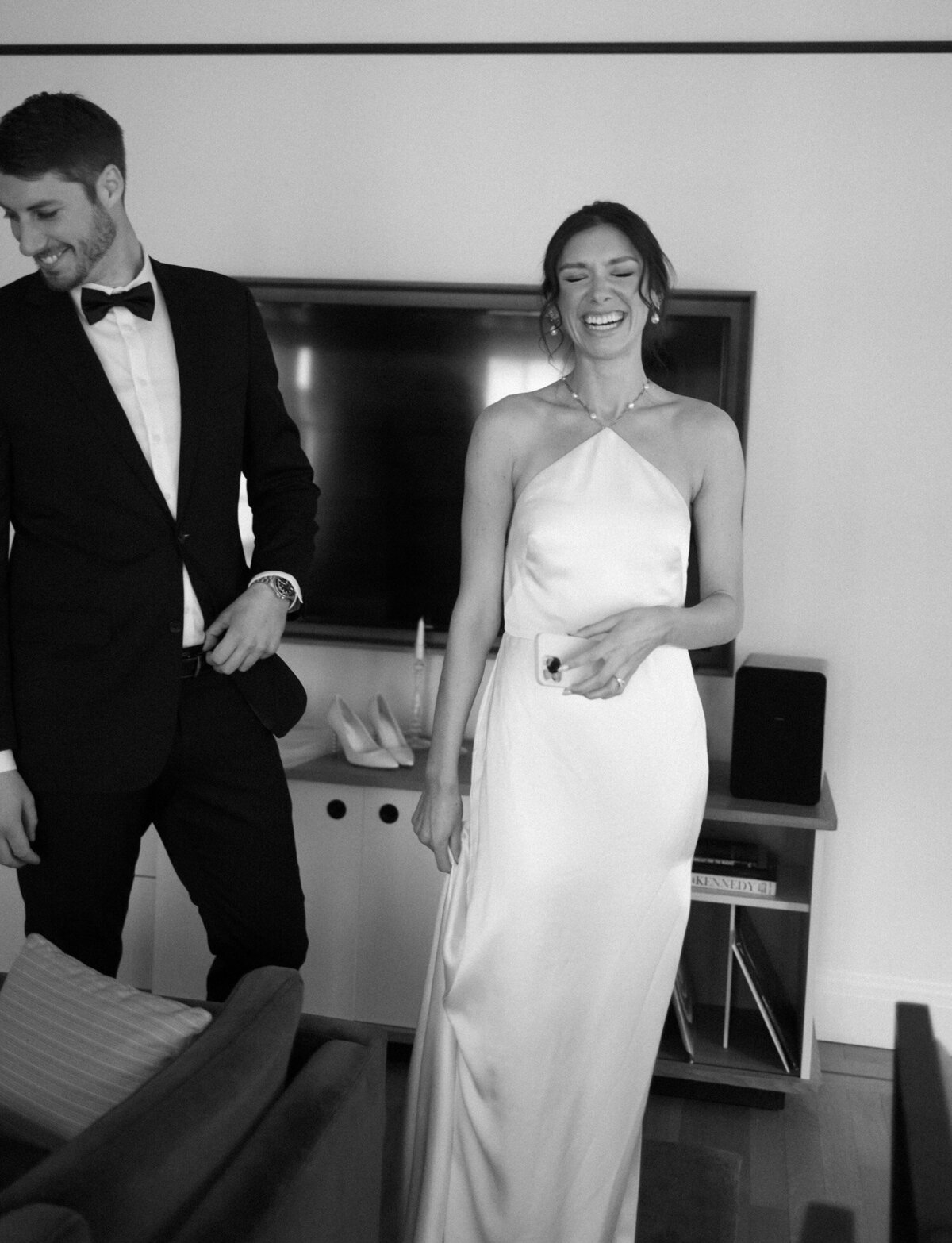 Bride and groom laugh in their suite at Shinola Hotel, Detroit