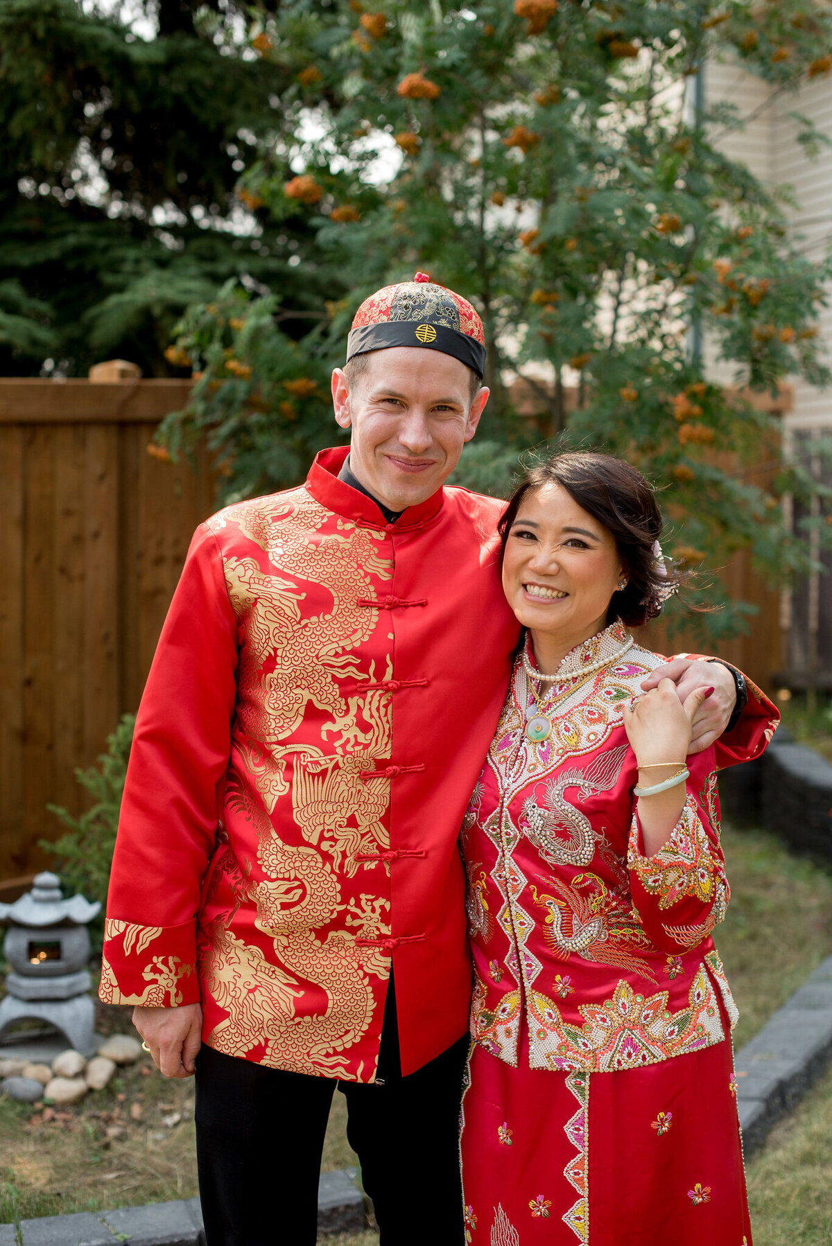 Multicultural wedding inspiration, couple in traditional Chinese wedding dress red and gold Qun Kwa at their Chinese Tea Ceremony, captured by Janelle Dudzic Photography, colourful and candid wedding photographer in Edmonton, Alberta. Featured on the Bronte Bride Vendor Guide.