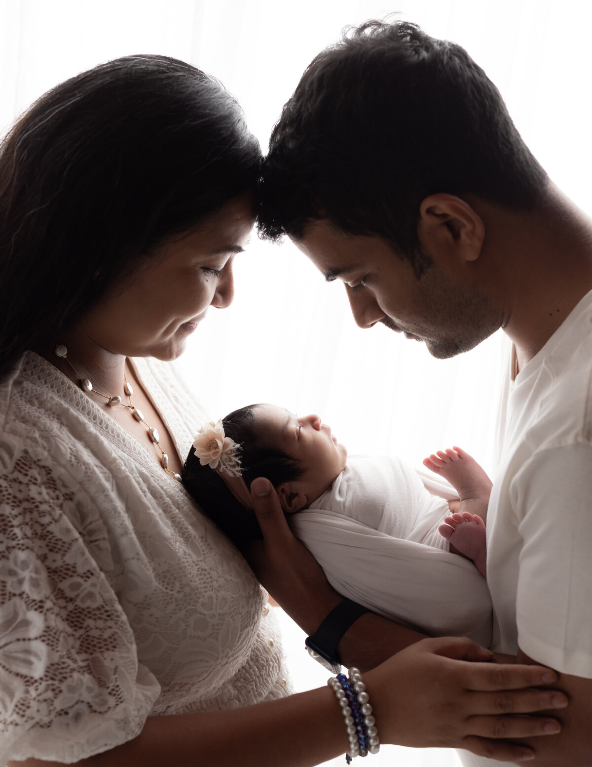 mom and dad holding newborn baby boy for photoshoot
