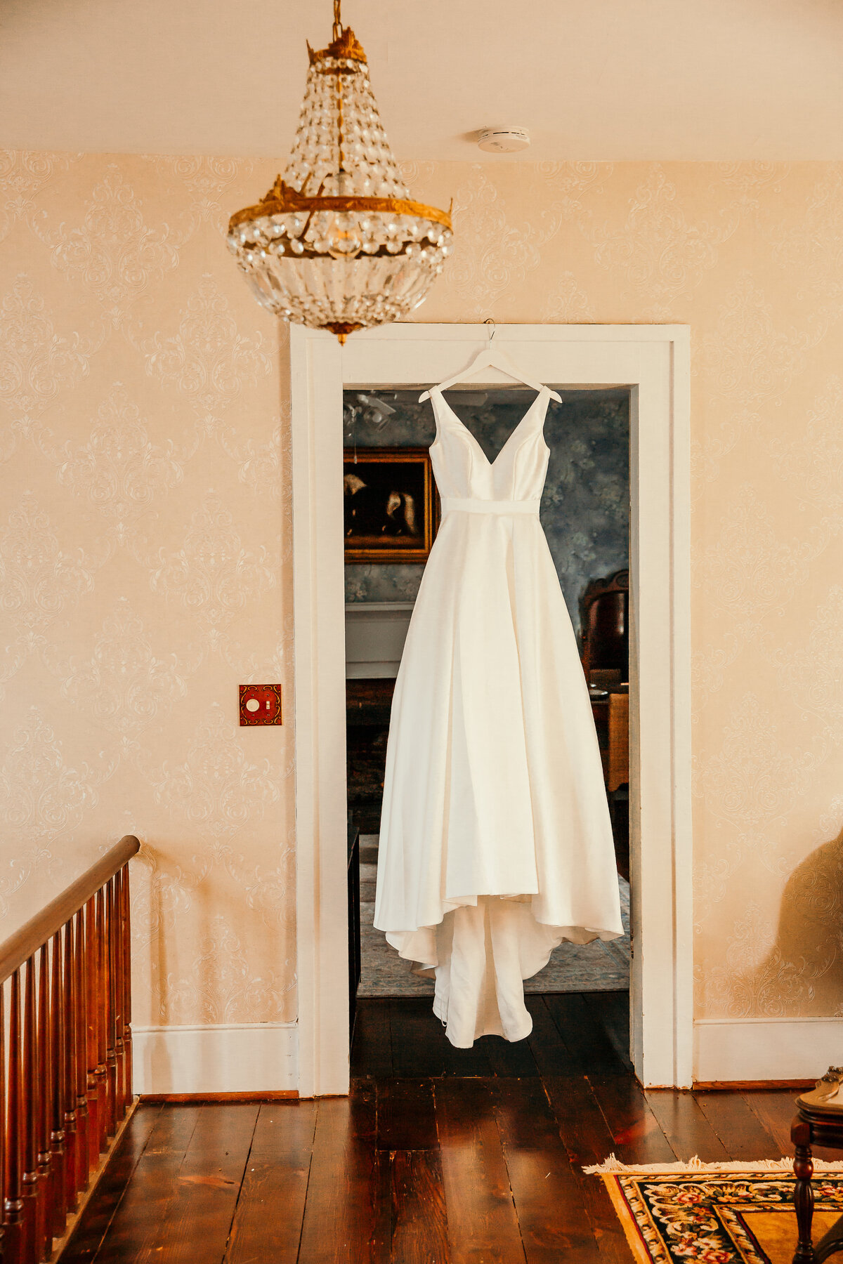 bride's wedding dress hanging in doorway