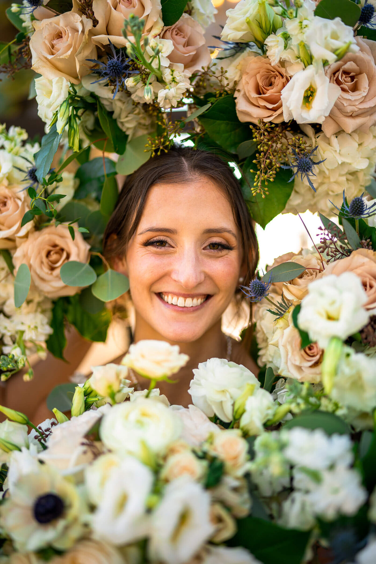 Pittsburgh bride smiling while her bridal party frames her with bouquets at a vineyard wedding venue in Ashville NC