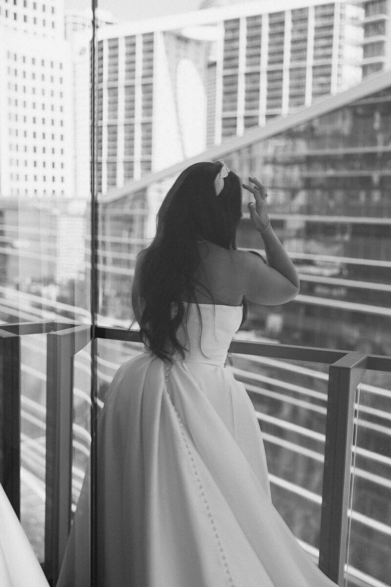 bride looking over balcony to show penthouse at riverside wharf photos