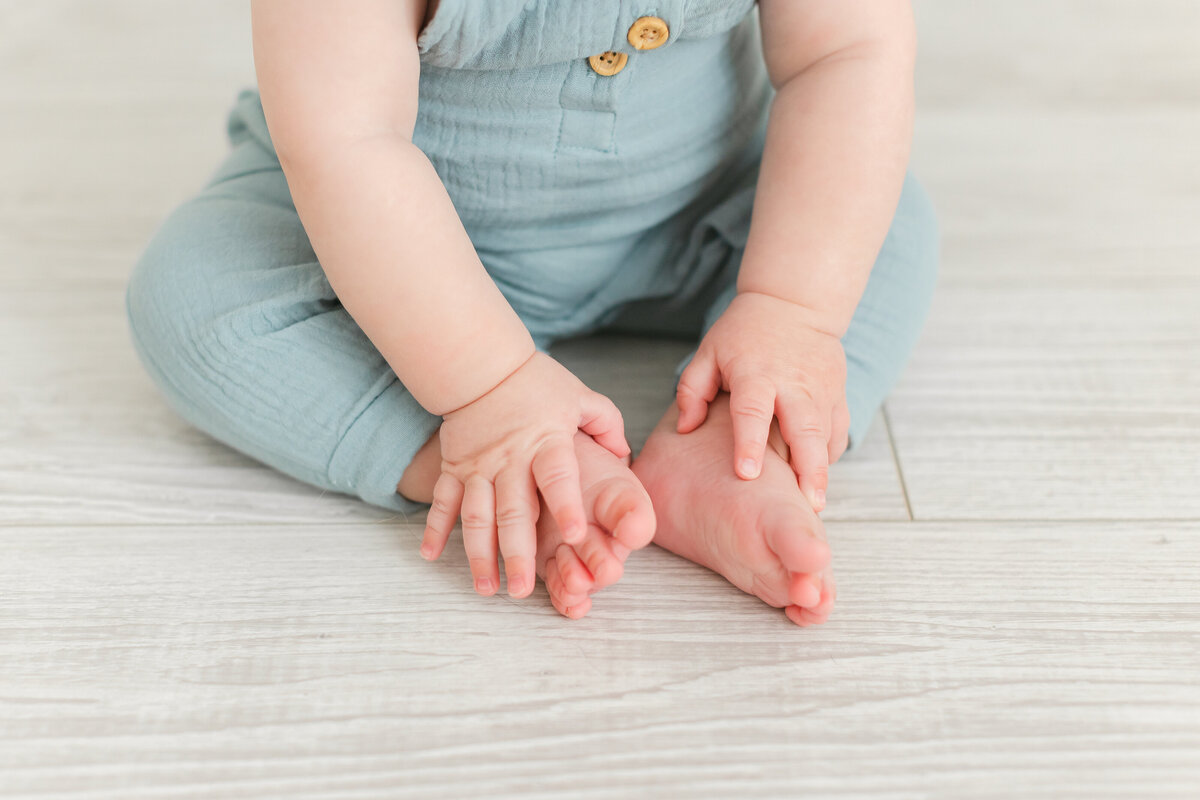 A Baby Photography photo in Northern Virginia of a baby holding his feet on the floor