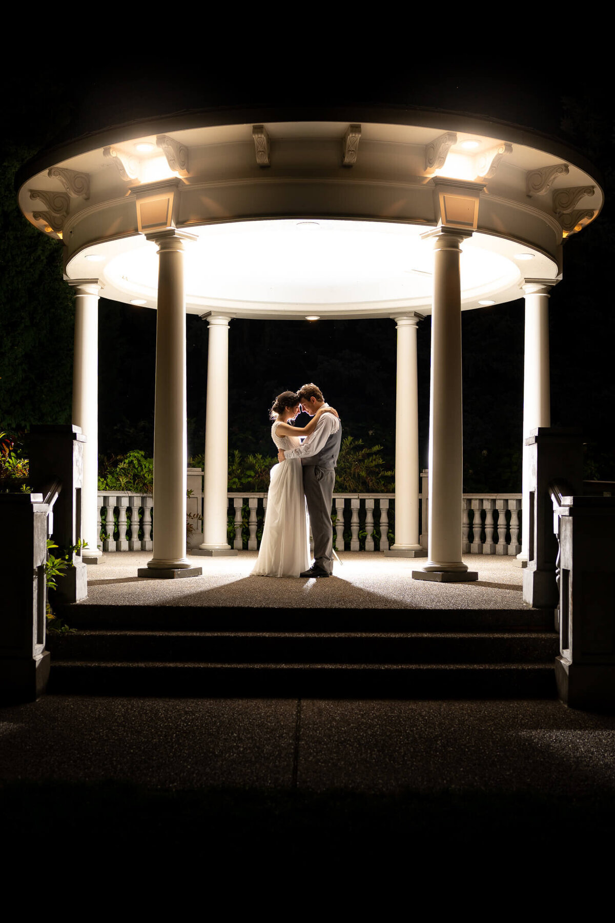Couple dances under the light of a gazebo at night during their wedding in Beaver PA.