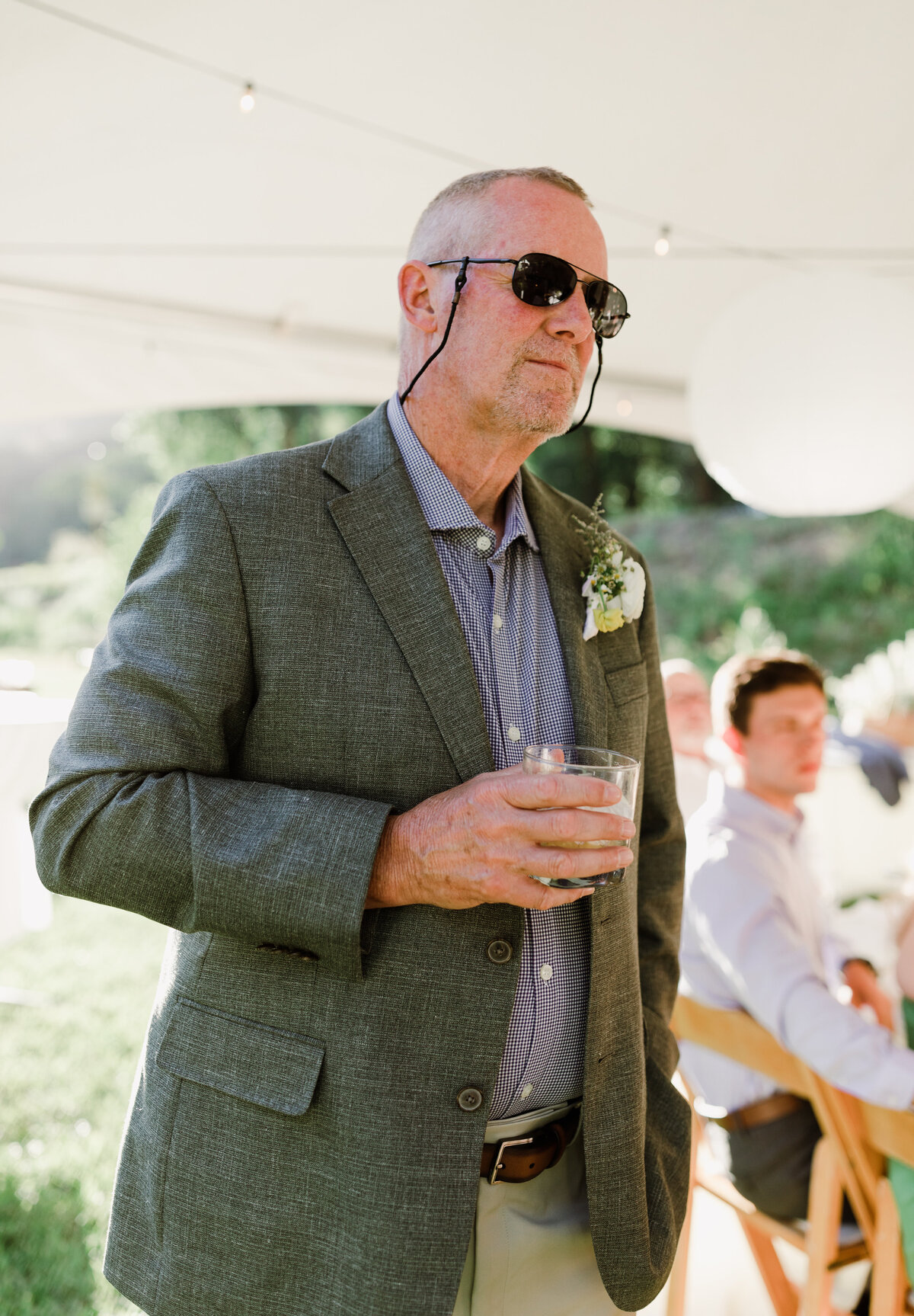 Man standing up holding.a drink at Dallenbach Ranch Wedding reception Colorado