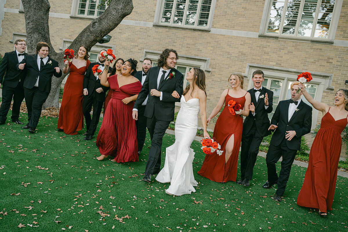 Editorial style portrait of large bridal party walking out of garden at luxury estate wedding in San Antonio