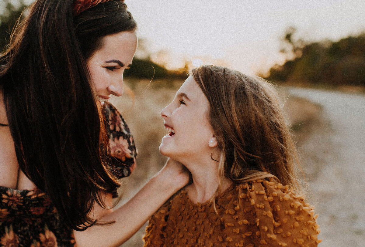 A mom and daughter looking at each other and smiling really big in Fort Worth, Texas