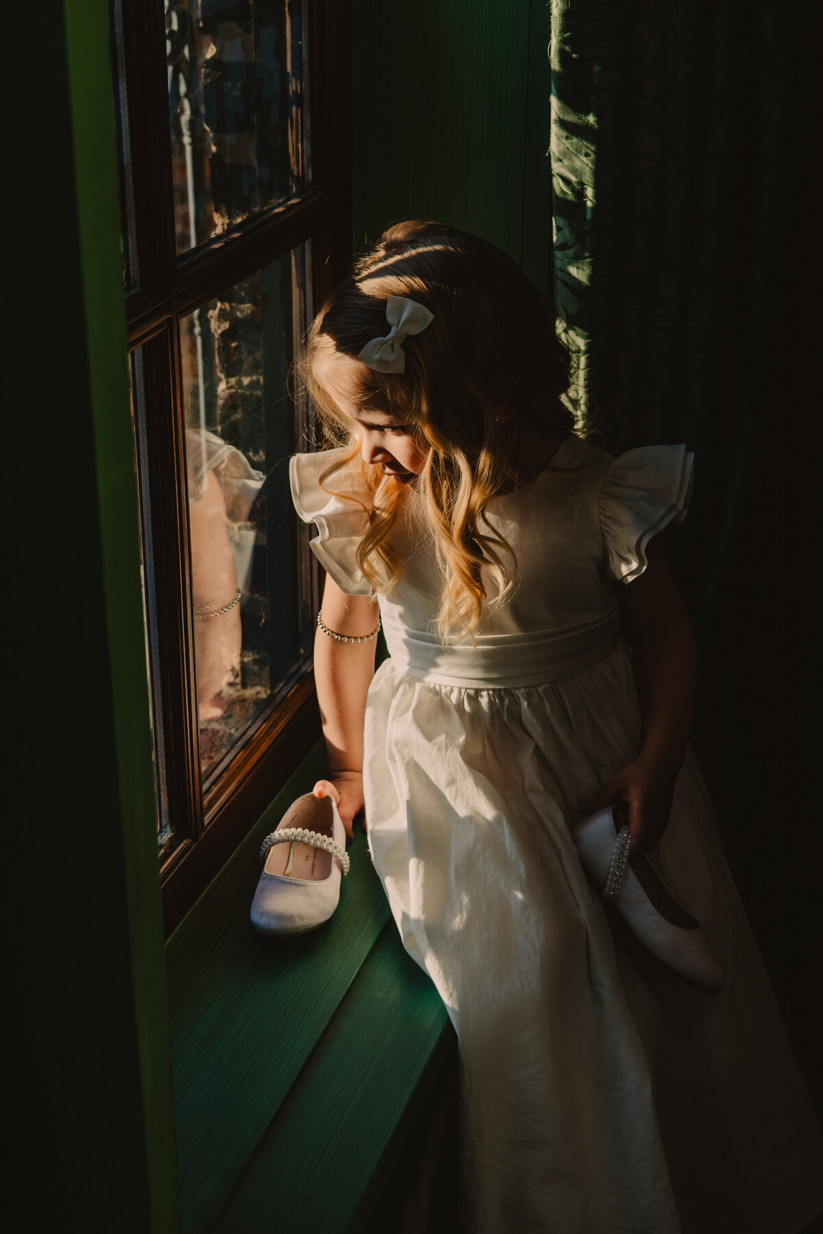 a small child sitting on a windowsill 