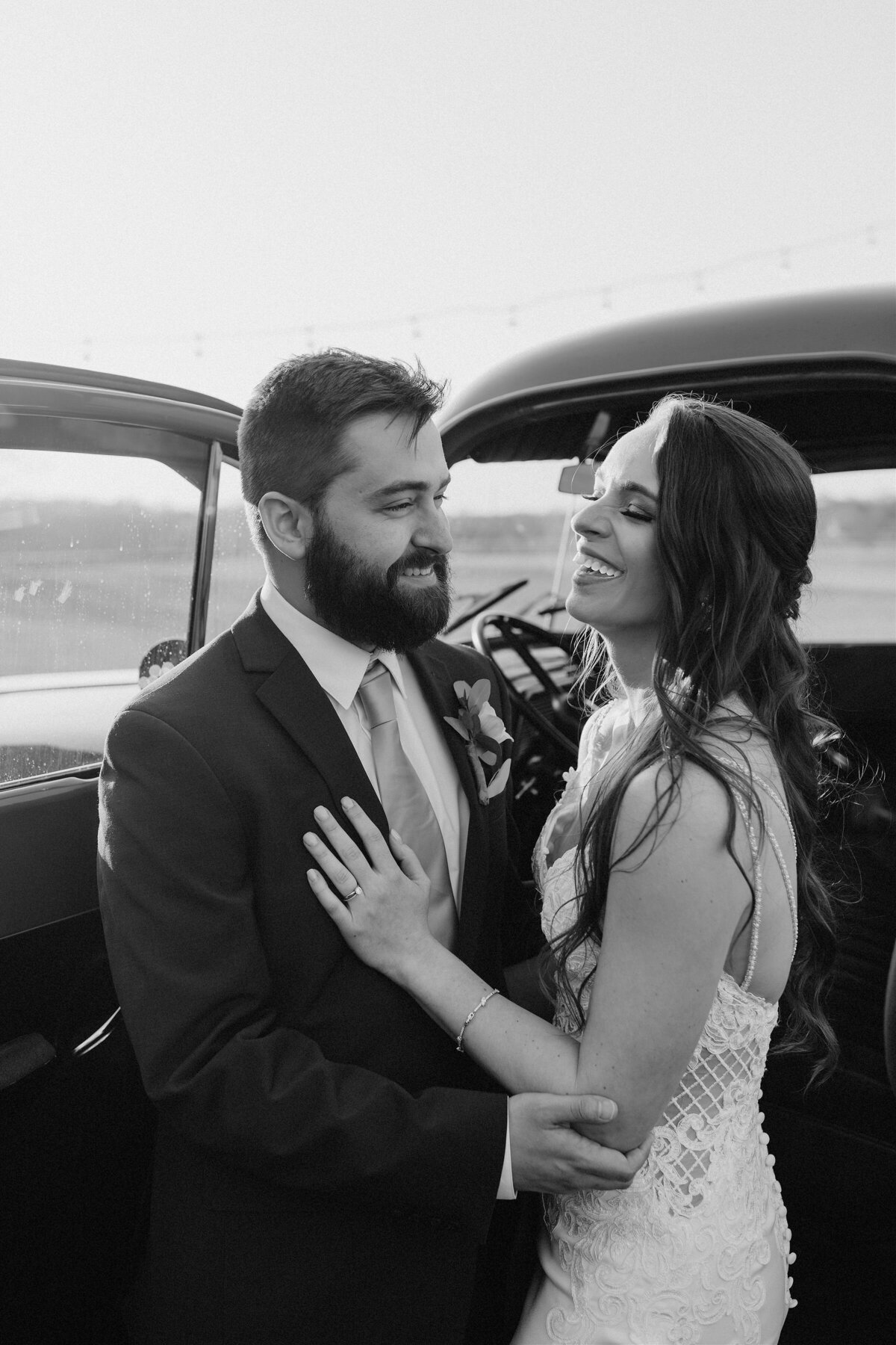 bride and groom stand by vintage car