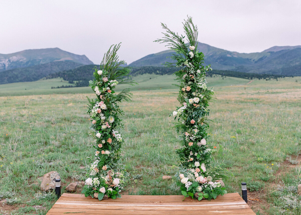 A green and pastel floral arch adorned the ceremony space of the bride and groom