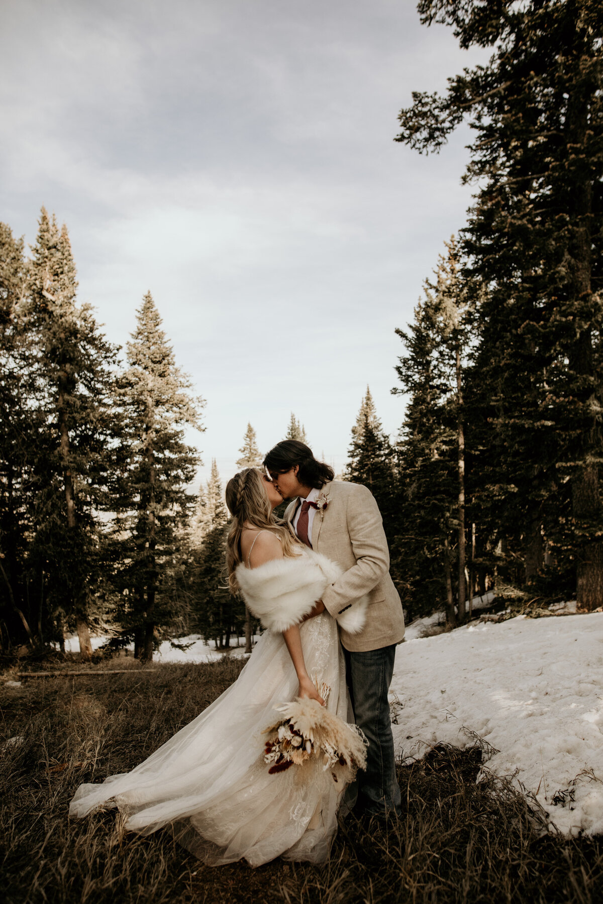 bride and groom kissing on the sandia mountain peak