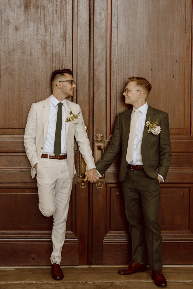 Two grooms hold hands and look at one another at the Union Station in Washington, DC