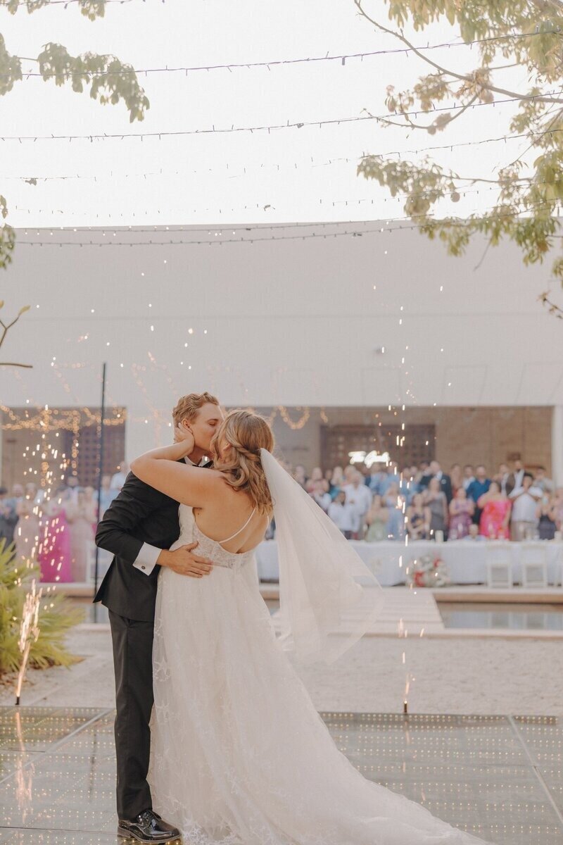 Couple kissing at wedding ceremony by travel planner for destination weddings