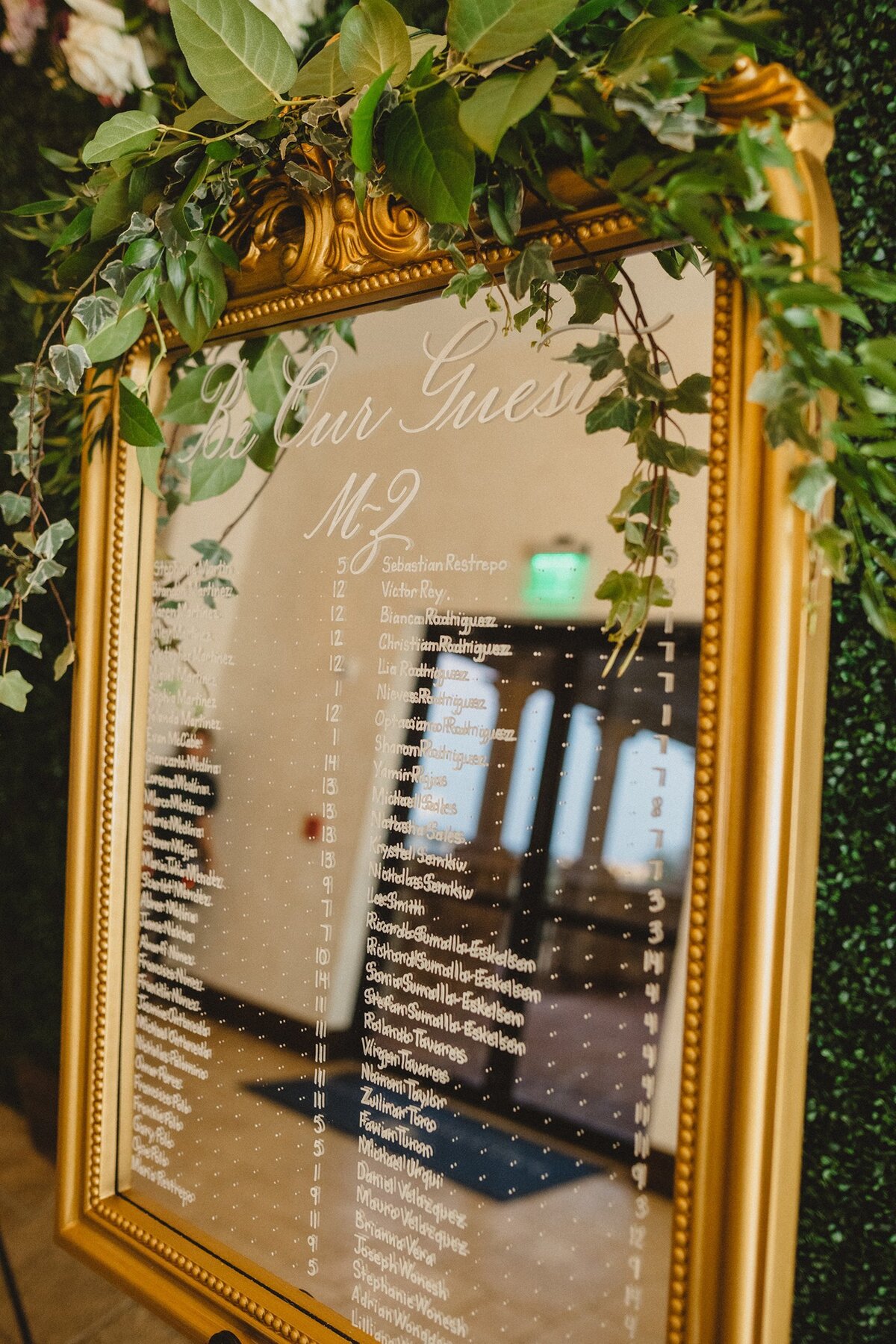 Medium vertical mirror with ornate ornament on top with calligraphy for seating chart