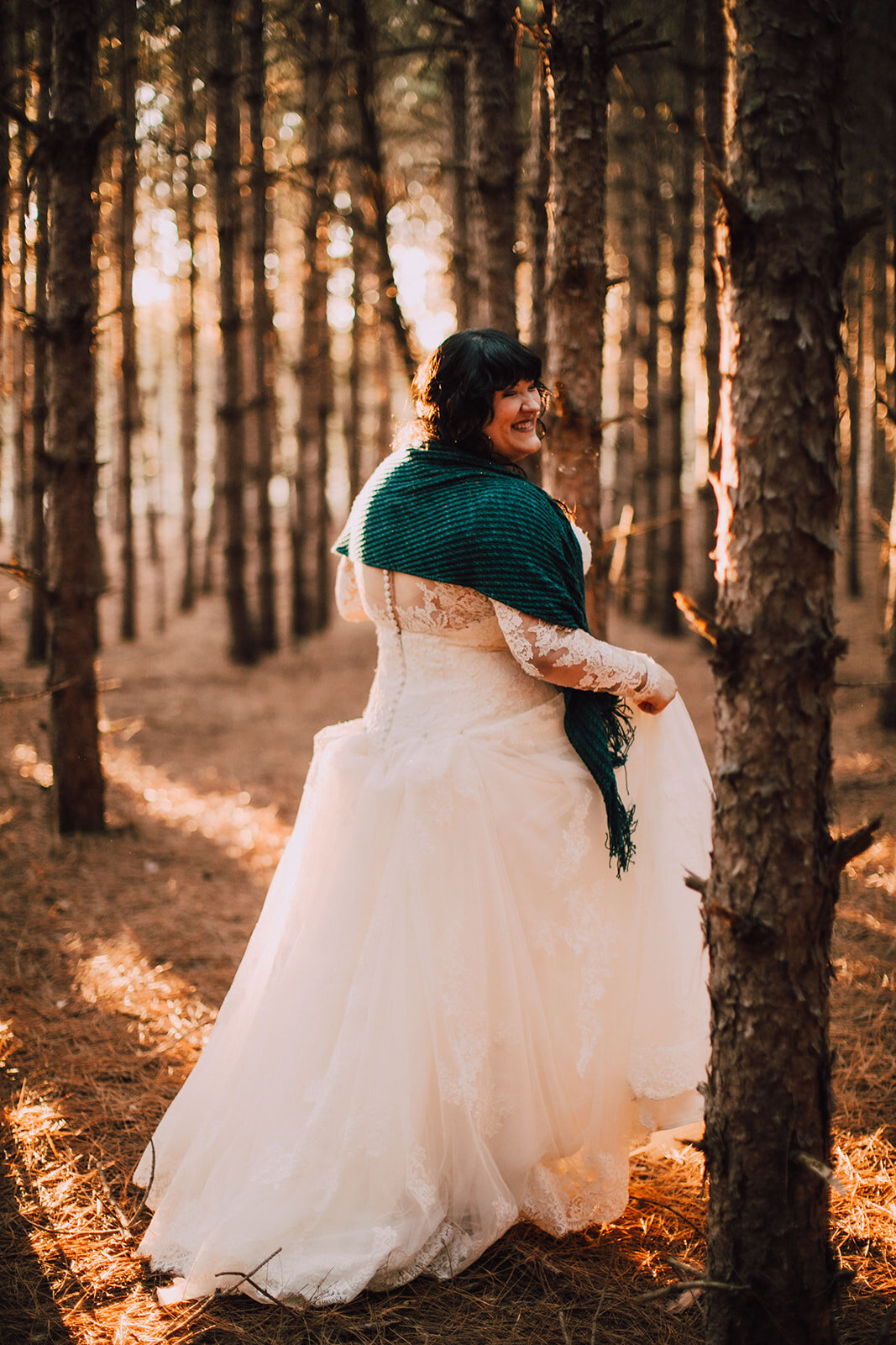 Bride walks through sunlit woods