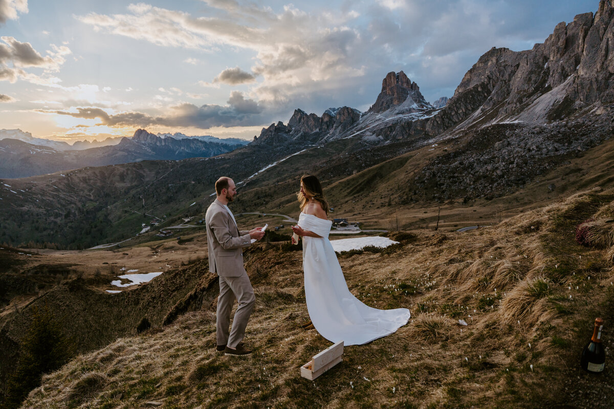 Couple holding hands during vow exchange on alpine ridge