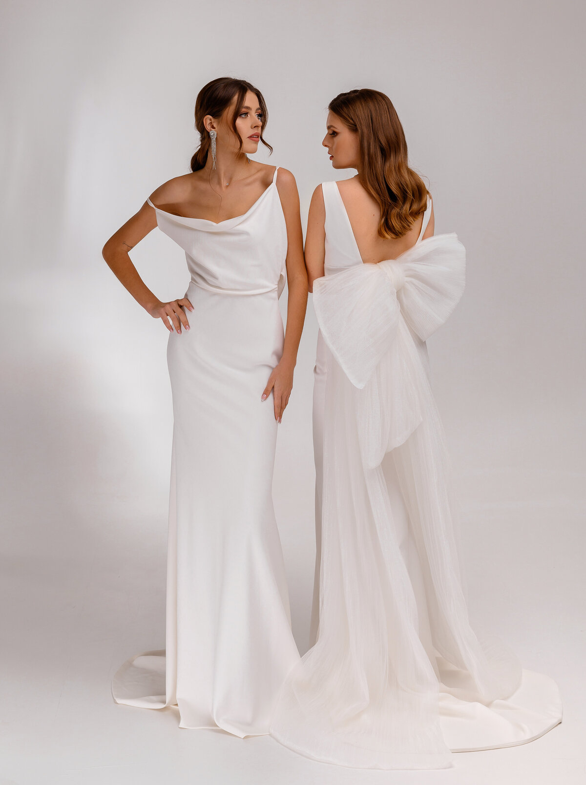 two-fashion-women-brunette-models-bridal-dresses-wedding-hairstyles-standing-together-posing-white-background-adorable-brides-wedding-jewelry-haircut-concept-wedding-salon