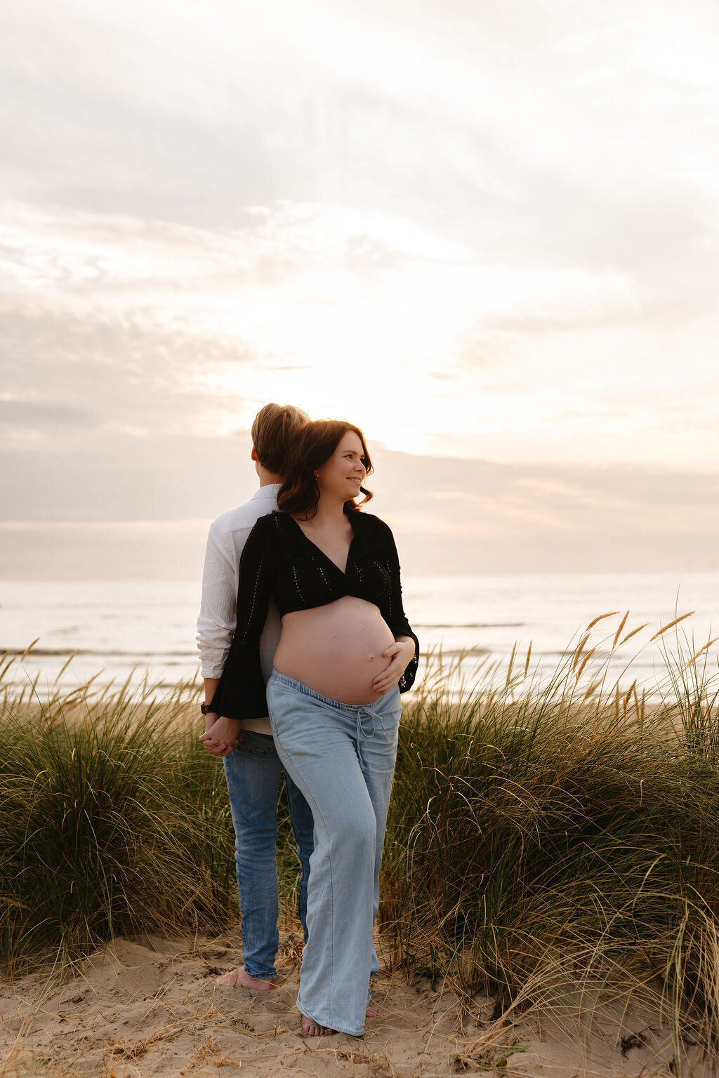Zwangerschapsshoot tijdens golden hour met koppel aan het strand van Katwijk