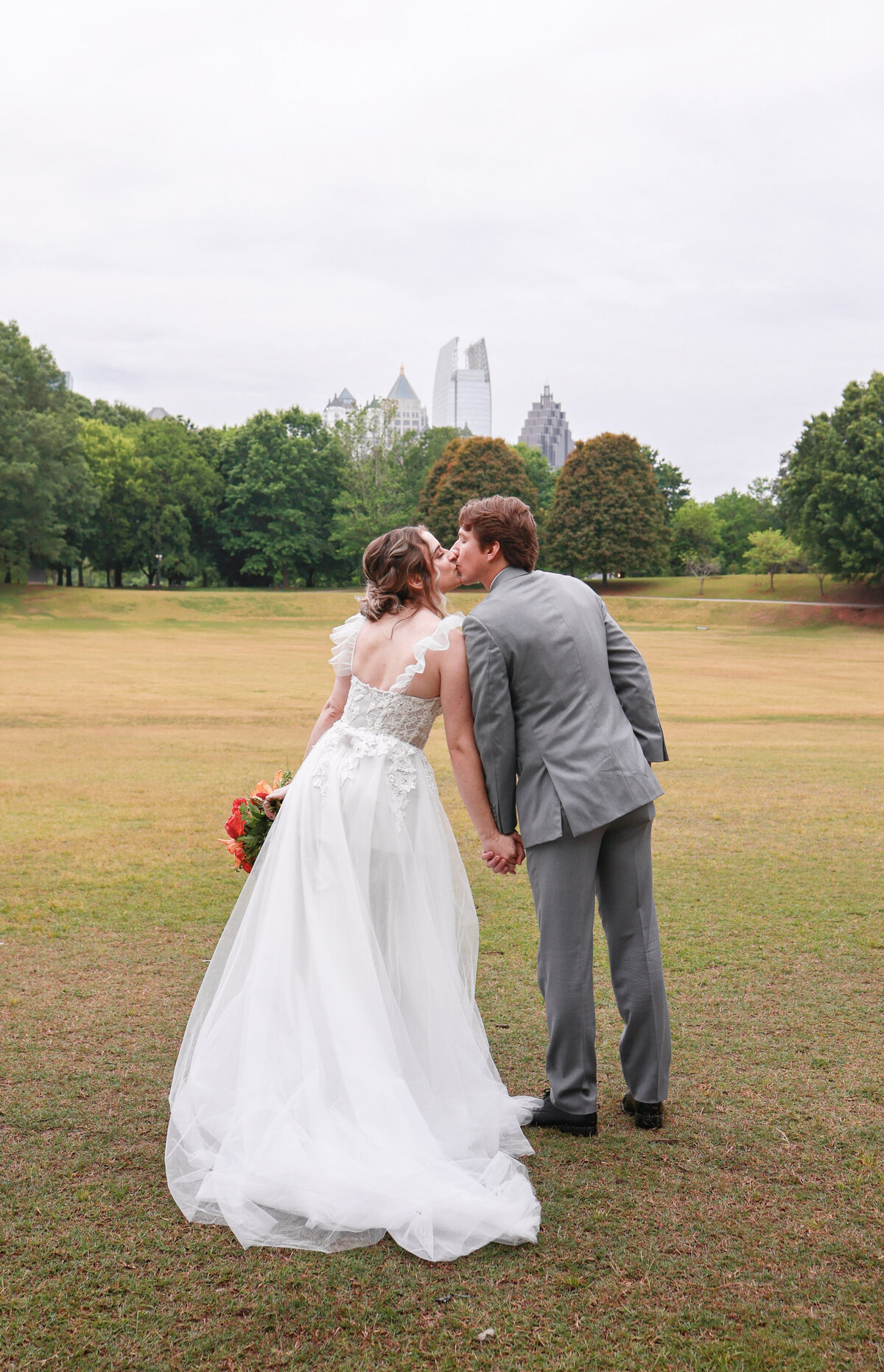 bride wearing tulle dress and groom wearing gray suit in piedmont park atlanta georgia by amanda richardson photography