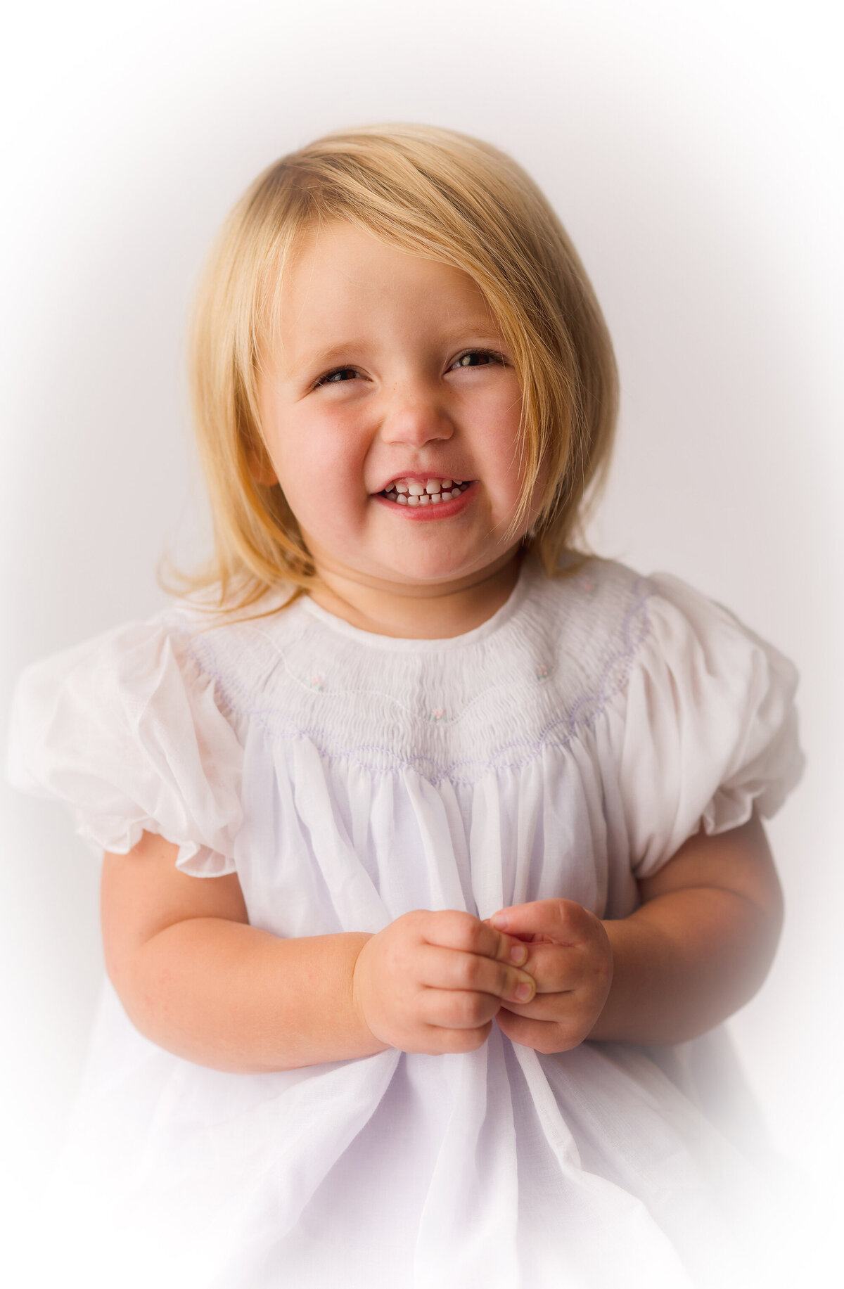 Little girl smiles at the camera for her Heirloom Portrait in Charleston, SC Photo Studio.