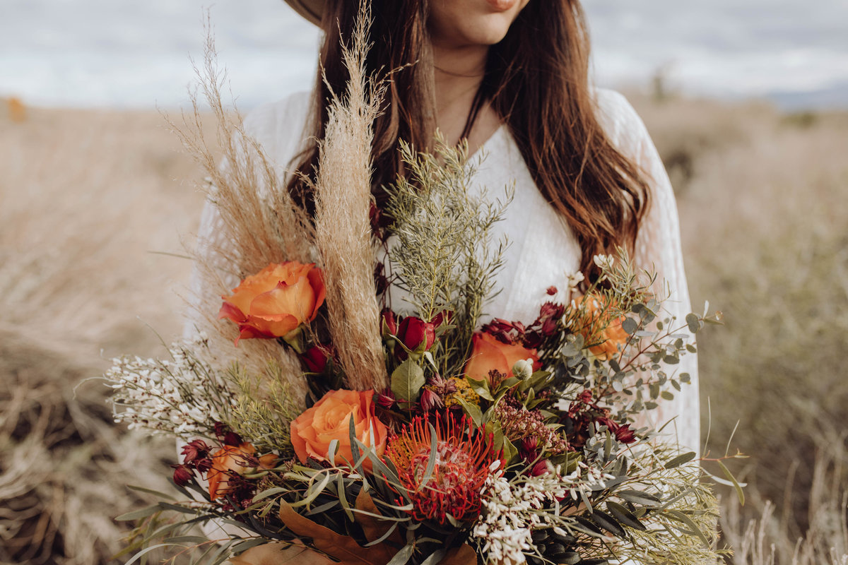 Close up photo of boho styled bouquet in the hands of the bride outside in Utah.
