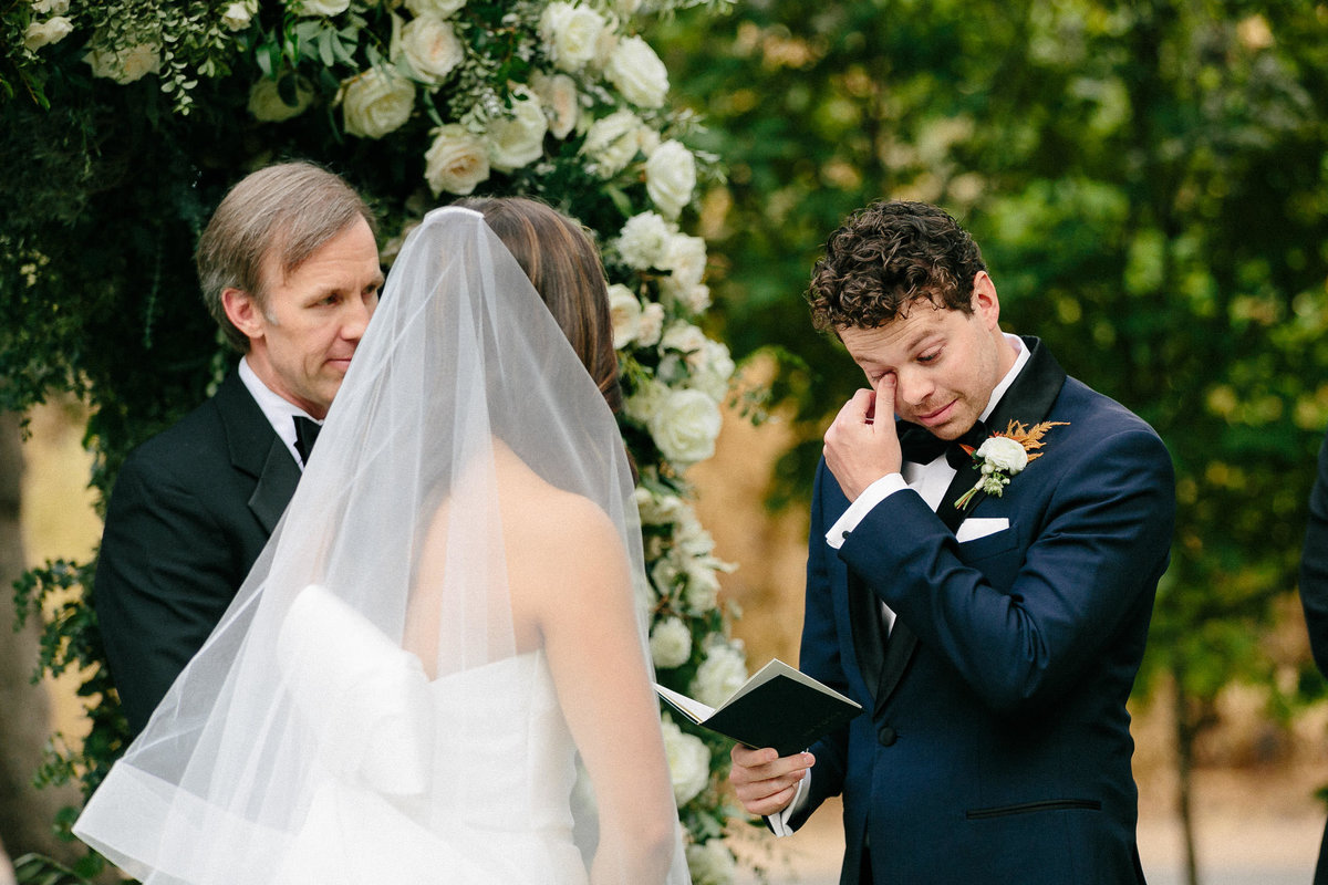 emotional groom reading vows to bride during wedding ceremony altar
