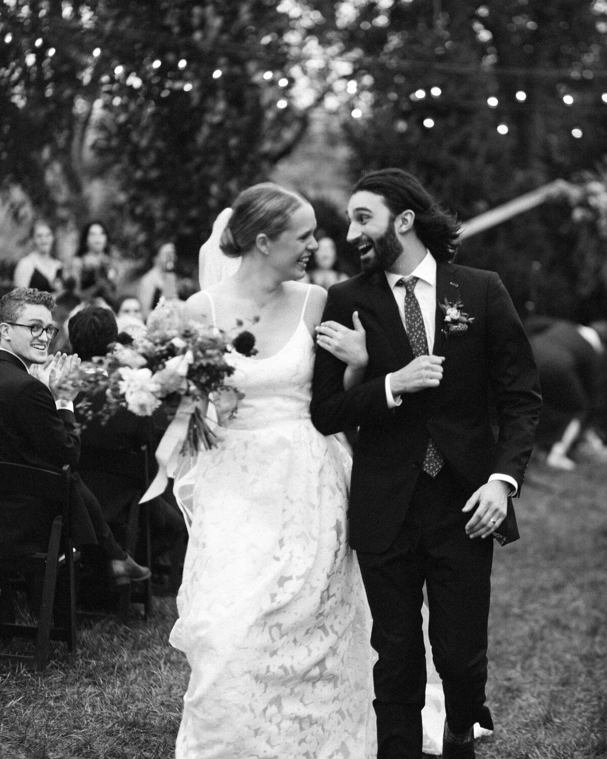Black and white image of couple excited after wedding ceremony