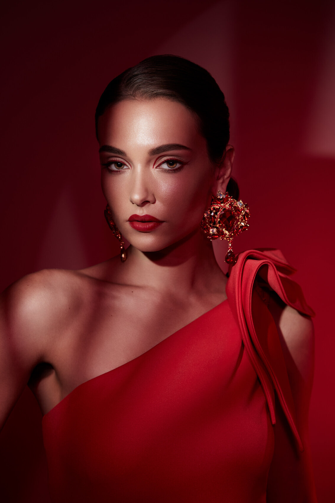 Luciana Cid in a bold red outfit, striking a confident pose in a studio portrait, photographed by Ylva Erevall.